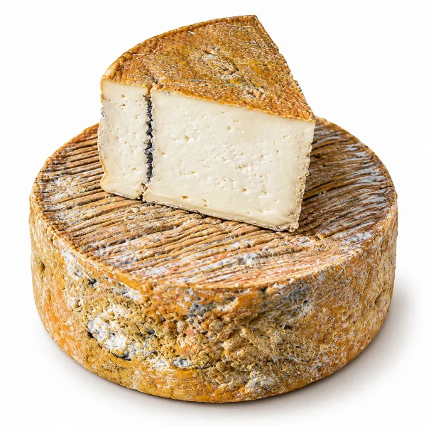 Una forma intera di Formaggio erborinato Blutunt Taddei, con uno spicchio appoggiato sopra